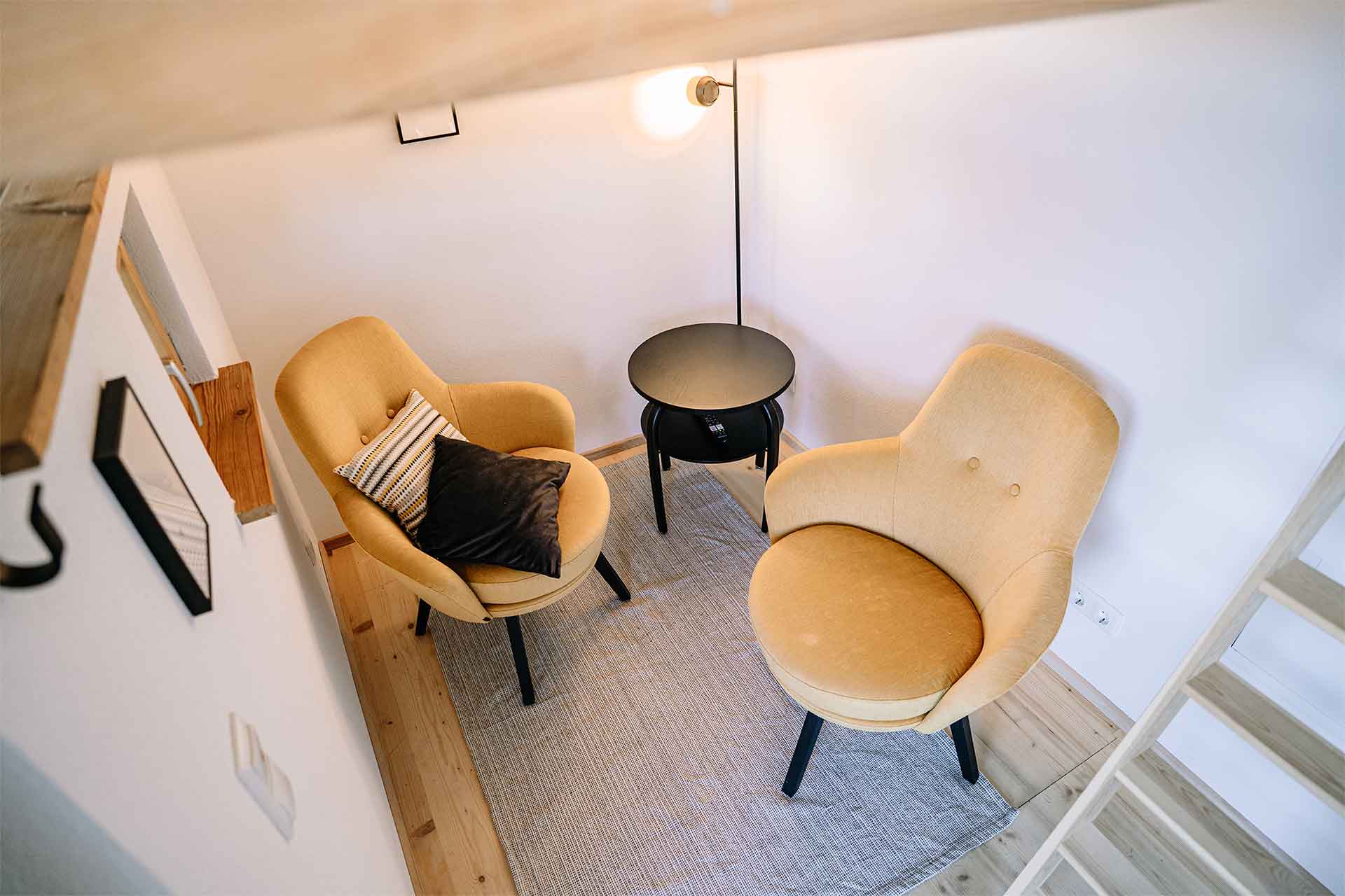 Gemütlicher Wohnbereich im Tiny House mit zwei Sesseln und kleinem Tisch.