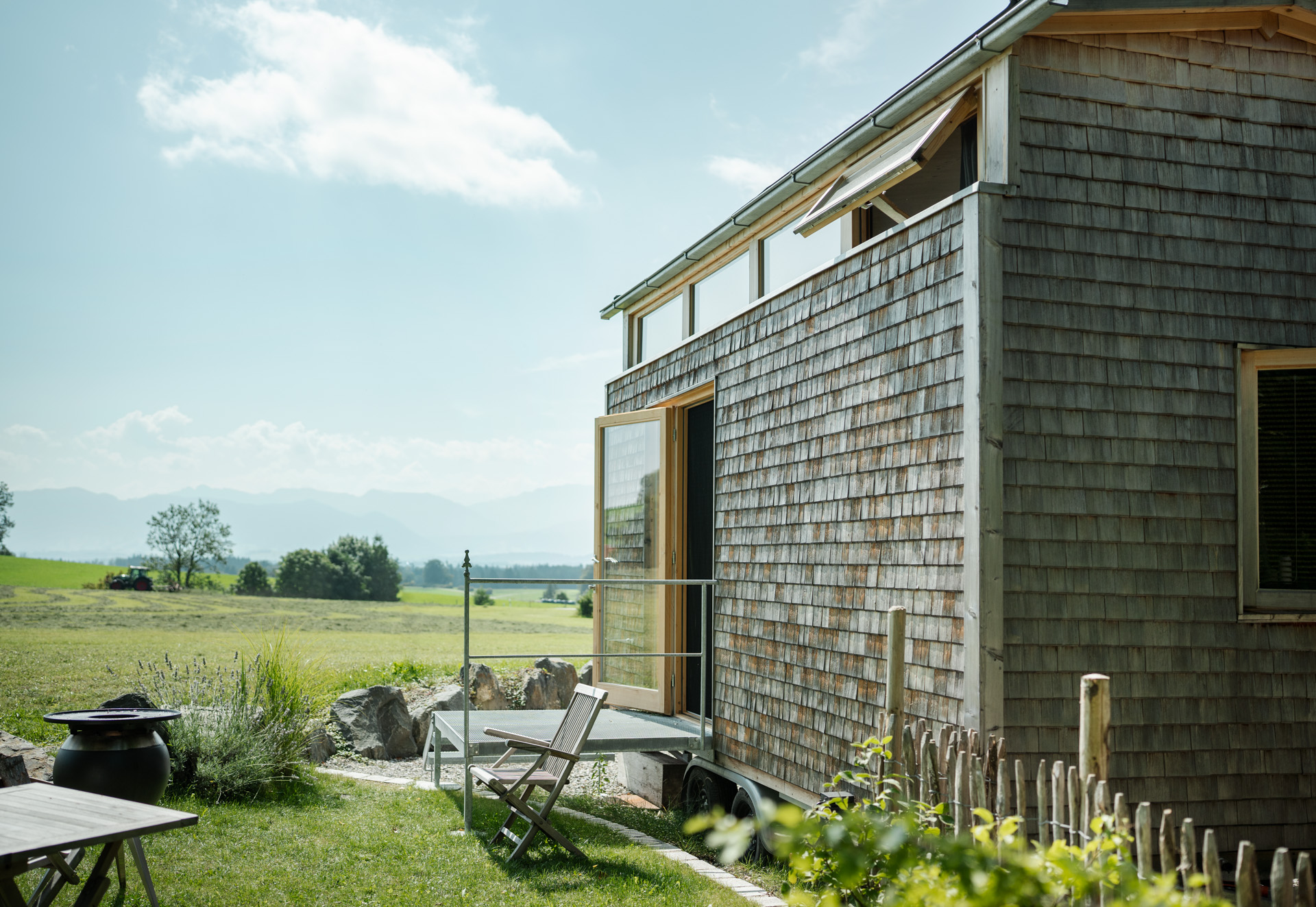 Ein geschindeltes Tiny House mit eigenem Garten und Bergblick steht an der Weide des Mächlerhofs im Allgäu