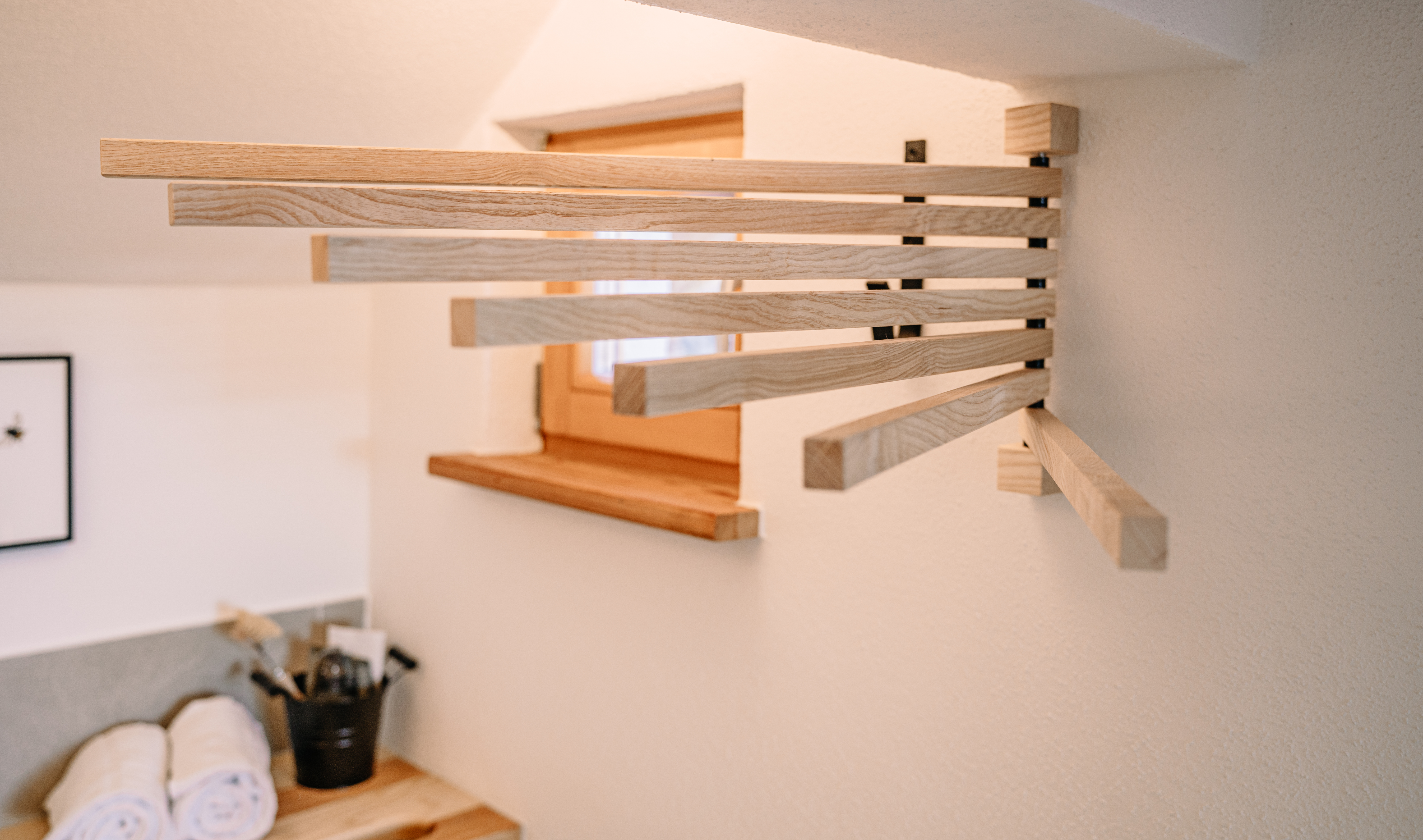Holzdetail eines ausziehbaren Wandregals im Tiny House.